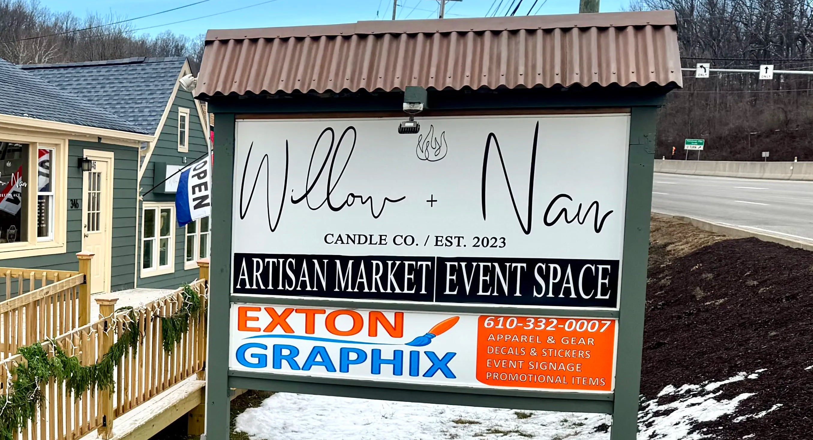 Exterior of a building with a sign for 'Willow & Vine Artisan Market Event Space' in front.