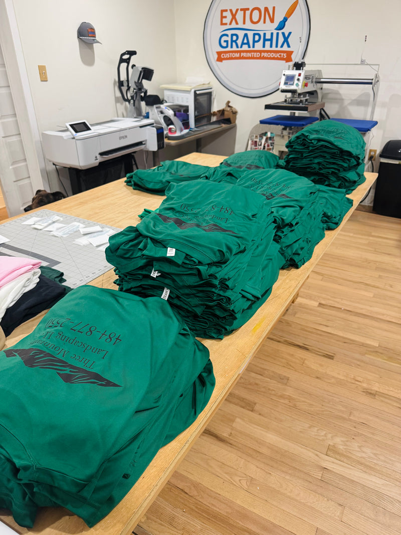 Stacks of polyester landscaping uniforms. 